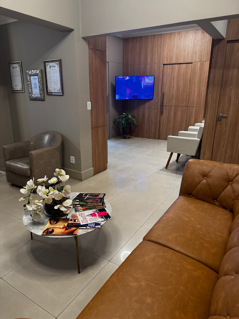 Lounge de espera com sofá de couro e TV