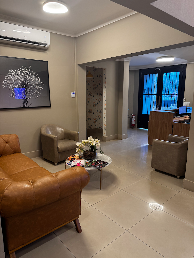 Sala de espera com poltronas de couro e iluminação suave